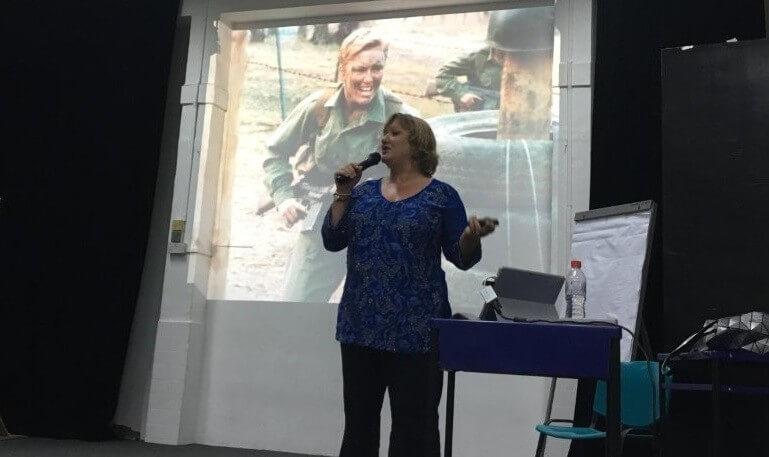 Andrea speaking on stage during a leadership session